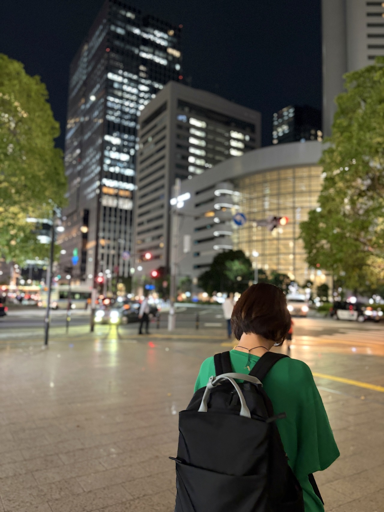 夜の梅田の街を背に歩く人