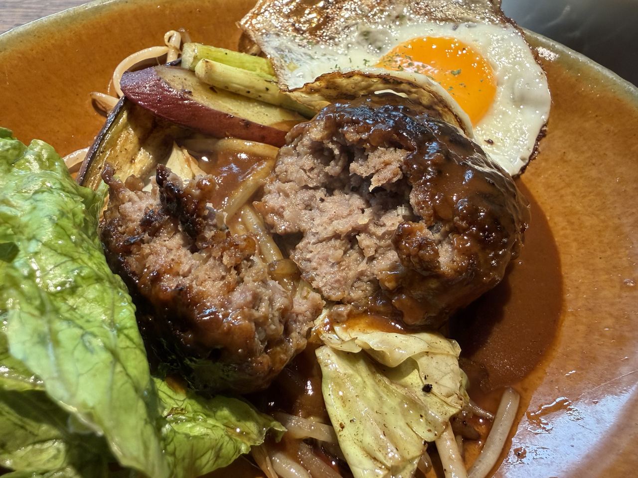 フォークで割ったオリーブ牛ハンバーグの断面、肉汁でしっとりした様子