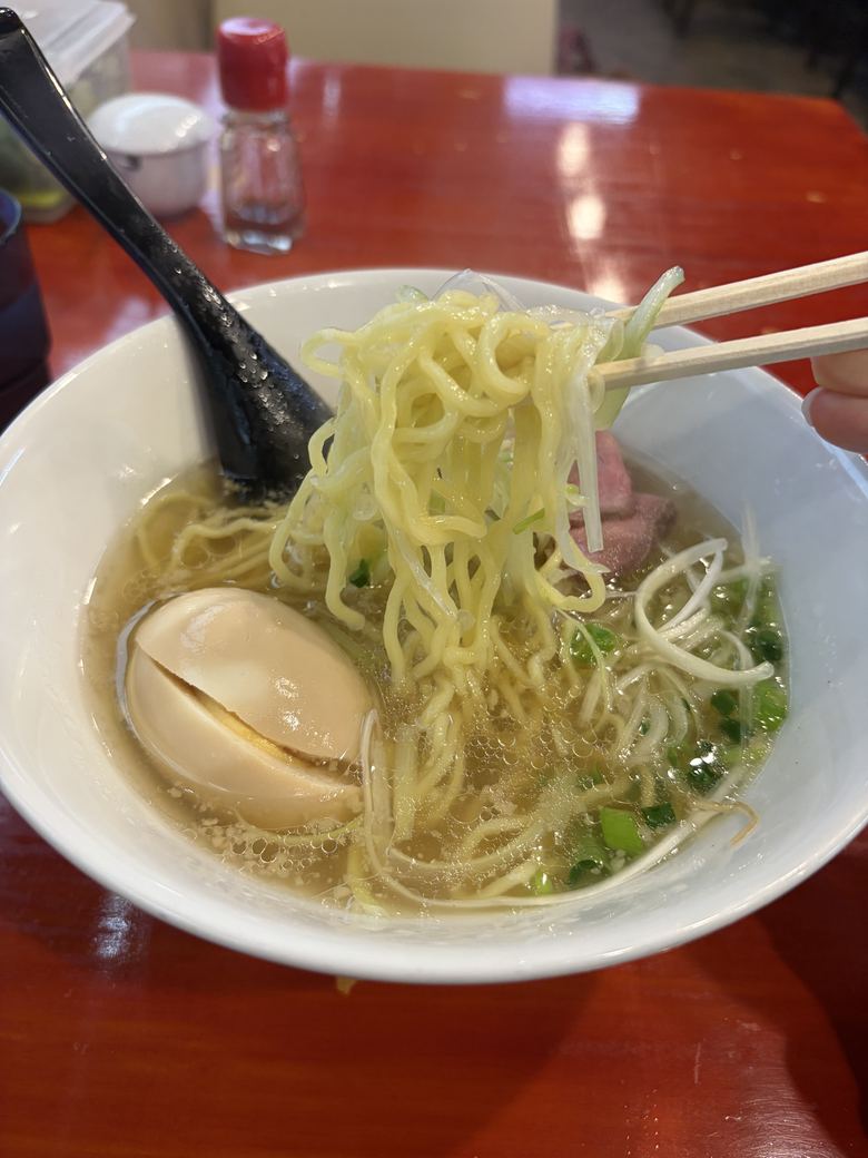 牛塩ラーメンの黄色い麺を持ち上げたところ